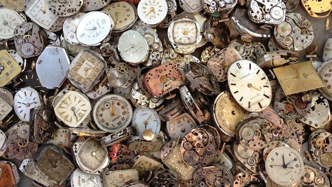 A big pile of old broken clocks